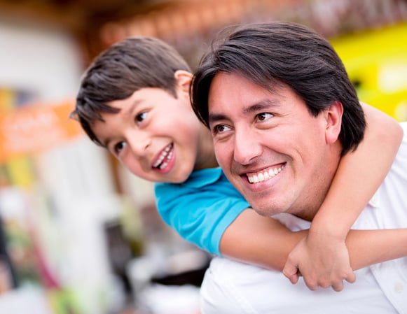 Happy father playing with his son and smiling